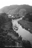 A view of the River Tamar at Nusticks, near Gunnislake, circa 1920. A paddles steamer is just heading back downstream having turned near the entrance lock to the Tamar Manure Canal is prominent in the centre. Photo by Chapman of Dawlish