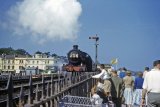 The classic location of Dawlish seafront with a Dwon Express departing watched by some youthful holidaymakers on 14th June 1958