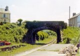 The road bridge over the line at the southern end of Llanybyther station in June 1974. Note: Photo taken with a 110 camera. The neg has deteriorated beyond use and the print is on a mottled surface photo paper, so this scan is the best we can achieve.
