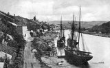 Calstock Quay circa 1900, looking down the River Tamar, with several sailing vessels loading. Lime kiln on left, East Cornwall Minerals Railway wagons on quay. Before construction of viaduct.