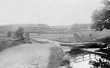 A swing bridge with a raised footbridge behind on a stretch of the Peak Forest Canal near Marple circa 1905.