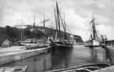 Pentewan harbour circa 1908 with several sailing ships in dock. Narrow gauge Pentewan Railway wagons on the left